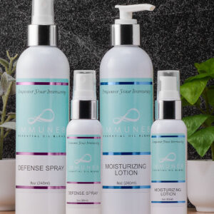 The image features four skincare products: a defense spray, moisturizing lotion, and two smaller bottles, all displayed with a greenery backdrop.