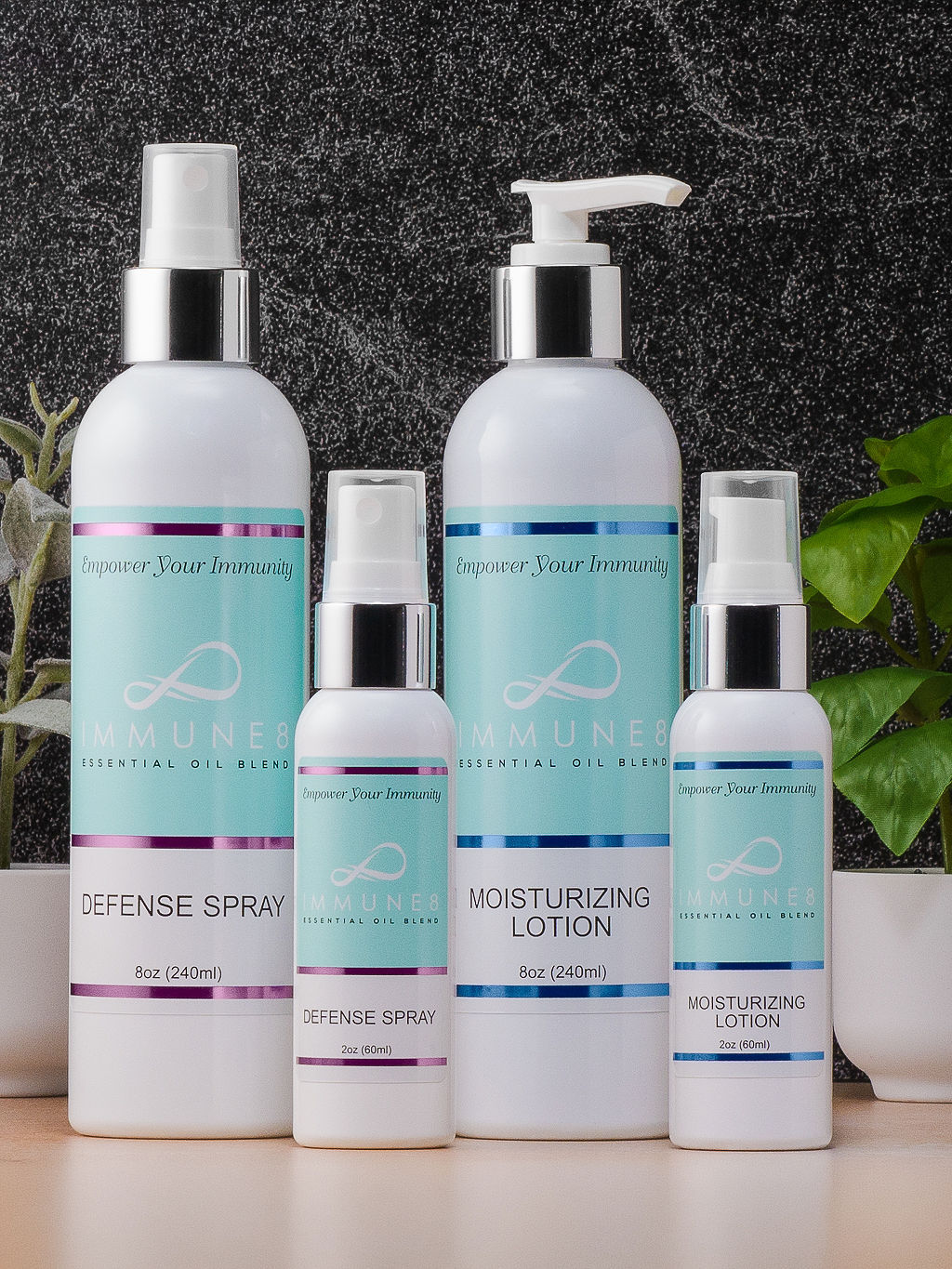 The image features four skincare products: a defense spray, moisturizing lotion, and two smaller bottles, all displayed with a greenery backdrop.